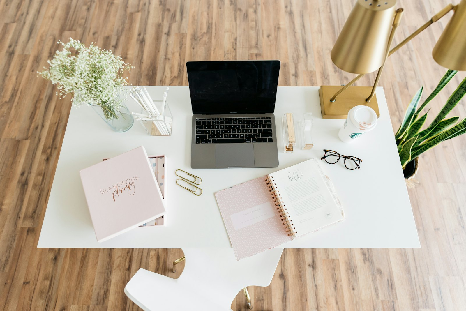 A tidy desk with a laptop and planner