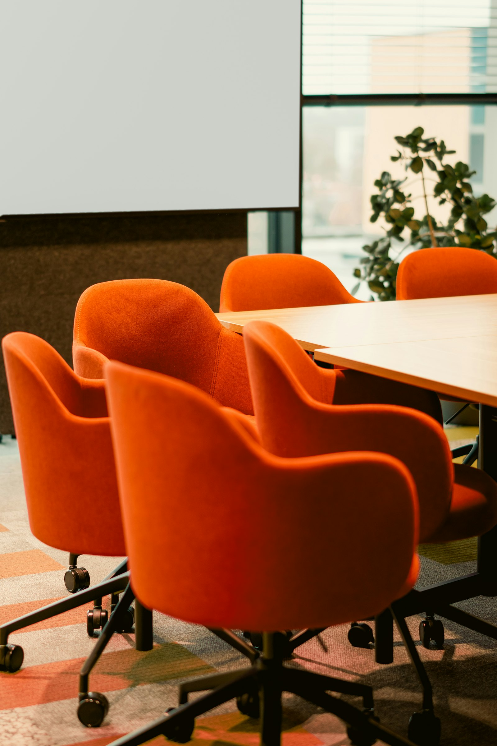 A modern meeting room with orange chairs